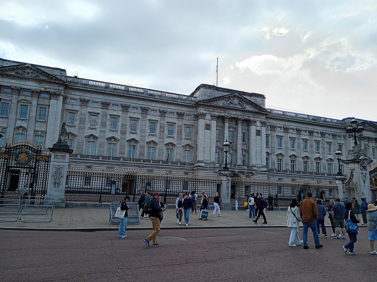 The broad stone front of Buckingham Palace with its gates and balcony under a bright sky
