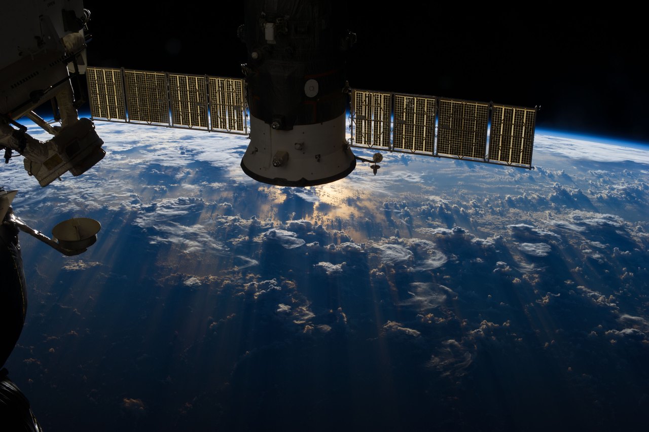 A view from orbit looking down on the Atlantic Ocean, where tall storm clouds pile up in bright white heaps above the dark water