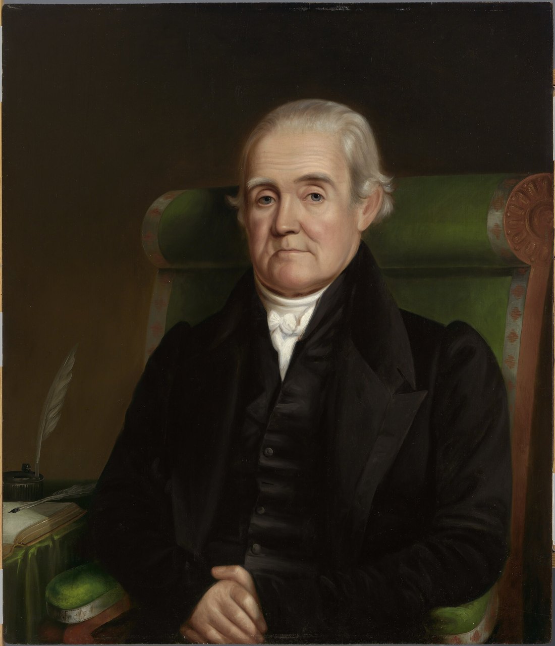 An oil portrait of an elderly white-haired man in a black coat and white cravat seated in a green armchair, with a quill pen and inkwell on the desk beside him