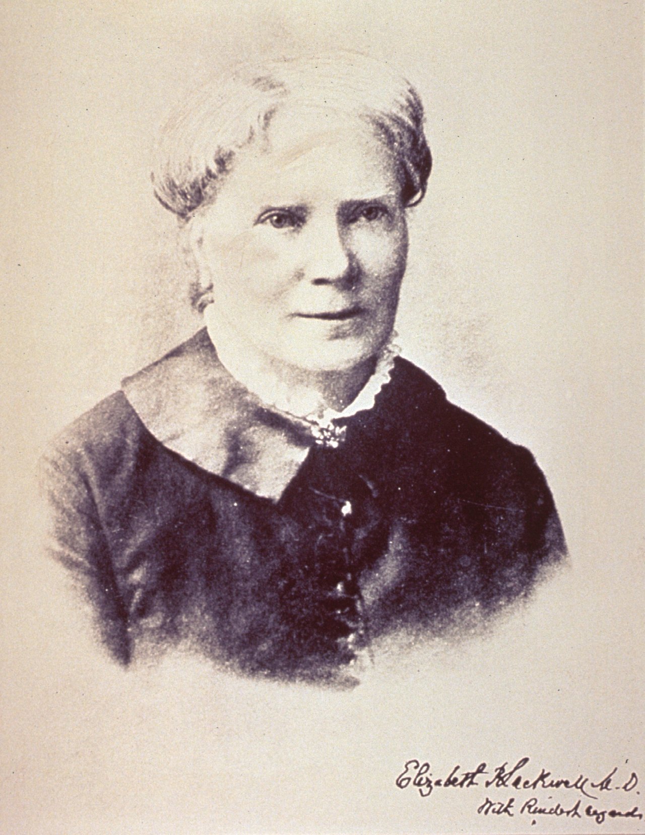A portrait of Elizabeth Blackwell in later life, her hair drawn back, wearing a dark high-collared dress, with her signature written beneath