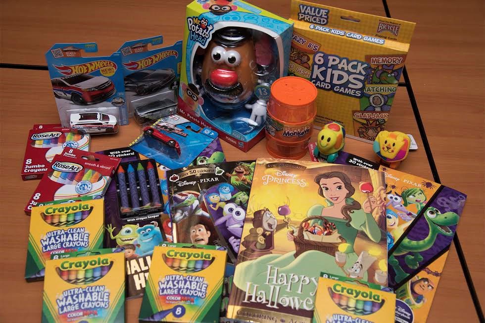 A table covered with new toys, colored pencils, board games and books, gathered together as a donation for a children's hospital