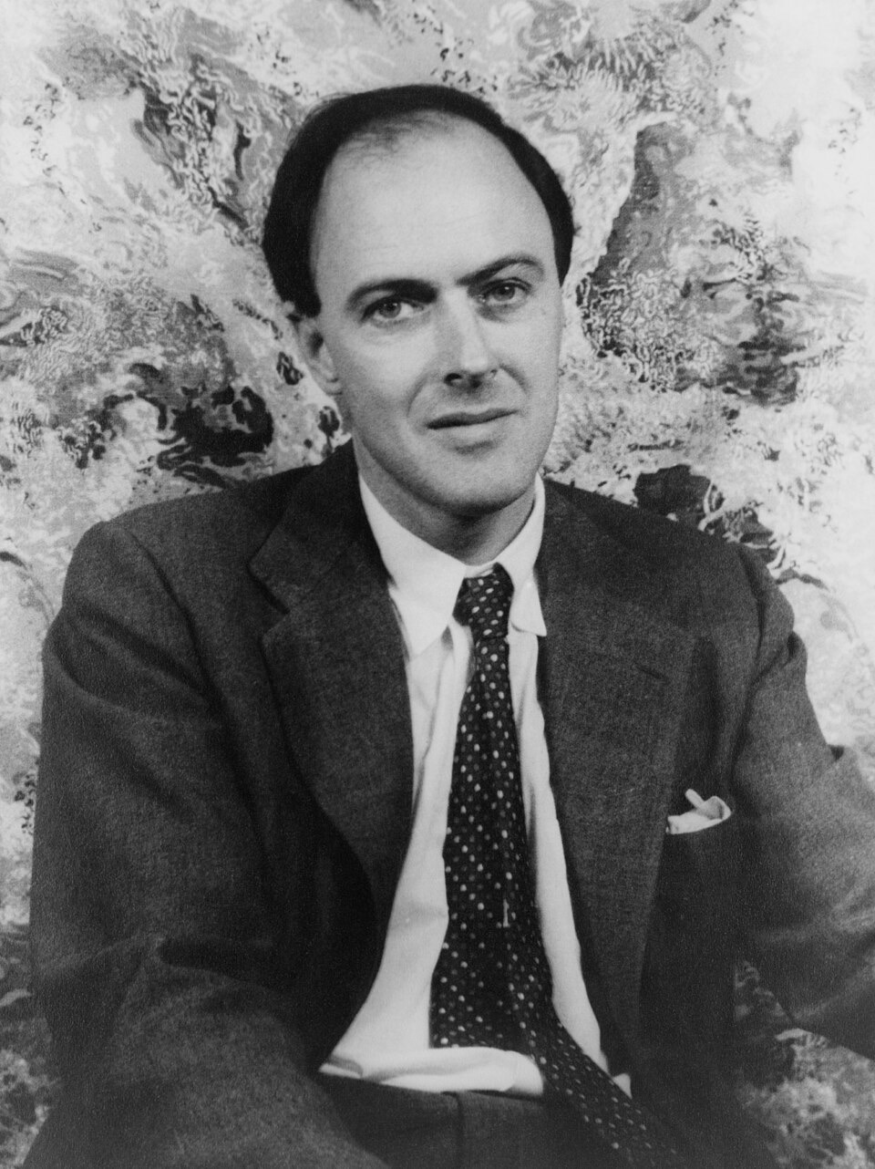 Black-and-white studio portrait of a man in a dark jacket, looking slightly to the side