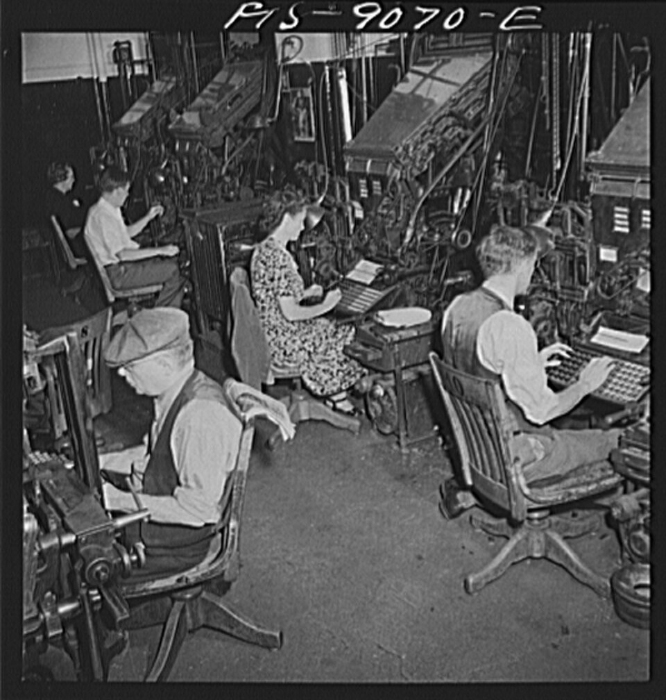 A black-and-white photograph looking across a composing room, where five operators sit at the keyboards of tall, machinery-crowded linotype machines